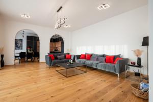 ein Wohnzimmer mit einem grauen Sofa und roten Kissen in der Unterkunft White Hill Villa in Masline