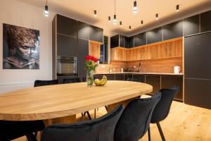 eine Küche mit einem Holztisch und schwarzen Schränken in der Unterkunft White Hill Villa in Masline