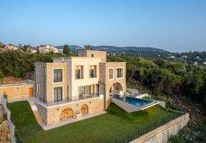 eine Luftansicht eines Hauses mit Pool in der Unterkunft White Hill Villa in Masline