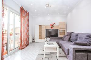 a living room with a couch and a tv at Central Beach Modernist Apartment in Lloret de Mar