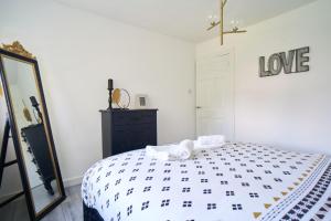 a bedroom with a bed with a love sign on the wall at Woodside Apartment in Coatbridge