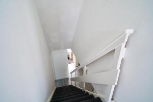 a staircase in a room with white walls and black stairs at Woodside Apartment in Coatbridge +27 photos