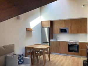 uma cozinha com uma mesa e uma cozinha com um frigorífico em BPIRINEOS- Aire Pirineos em Benasque