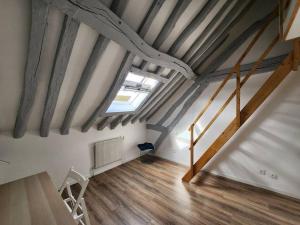 Zimmer im Dachgeschoss mit einer Treppe und einem Fenster in der Unterkunft Le Saint Julien - 5 chambres, spacieux et calme in Rouen