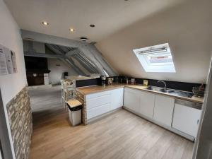 una cocina con armarios blancos y fregadero en Le Saint Julien - 5 chambres, spacieux et calme, en Rouen