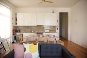 a living room with a blue couch and a kitchen at Link Alcácer in Alcácer do Sal