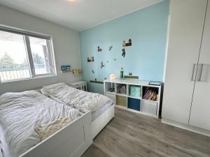 1 dormitorio con cama blanca y ventana en Apartment Lyngas - Birta Rentals en Garðabær