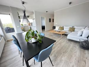 a living room with a black table and blue chairs at Apartment Lyngas - Birta Rentals in Garðabær