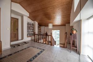 a living room with a wooden ceiling and a staircase at Exclusiva Casa Rural Mariano con acceso directo al rio in Baralla