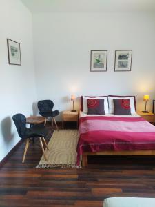 1 dormitorio con 1 cama y 2 sillas en Bíbor-lak ökoszálláshely, en Pannonhalma