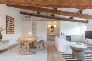 a living room with a wooden table and a white couch at Maison Salix in Vallabrègues