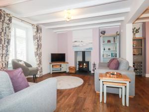 a living room with a couch and a table at Still Waters in St Austell