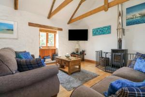 a living room with two couches and a tv at Mill in Porthleven