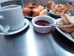 una mesa con platos de repostería y una taza de café en Condor en Mina Clavero