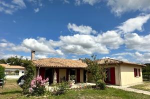 una piccola casa con un cielo azzurro con nuvole di Le mas des anges a Soussans