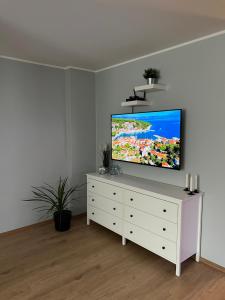 a living room with a flat screen tv on a white dresser at Kreutzwaldi Kodu 2 in Võru