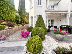 ein Haus mit einem Garten mit Blumen und Pflanzen in der Unterkunft Exquisite-Suite für Comfort & Gemütlichkeit Parkplatz ,Terrasse, WLAN 