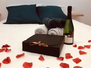 a bottle of wine and a box of towels and a bottle of champagne at NEMAUSA APARTIS in Nîmes