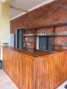 een houten bar in een kamer met een bakstenen muur bij Kelingking Hostel in Klungkung