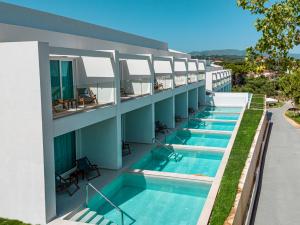 特拉加基的住宿－Mirage Bleu Hotel，建筑物一侧的一排游泳池