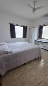 una camera da letto con un grande letto e una finestra di Bangalô 12 na praia de Guaratiba, Prado, ba a Prado