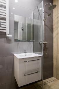 uma casa de banho branca com um lavatório e um chuveiro em ADLER Room Suite -- prywatna łazienka, dostęp na kod -- BEZPŁATNY PARKING em Lódź