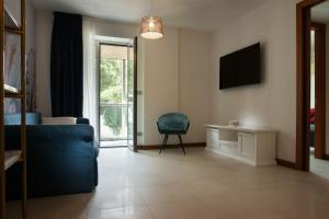ein Wohnzimmer mit einem blauen Sofa und einem TV in der Unterkunft Vespucci Home in Rimini