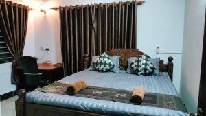 a bedroom with a bed with a wooden headboard at La maison de Soriya - Work & Stay in Kampot