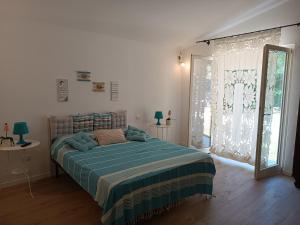a bedroom with a bed with a blue comforter at Sorgenti nel bosco Appartamento vista lago in Campo Reggiano