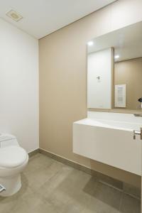 La salle de bains est pourvue de toilettes, d'un lavabo et d'un miroir. dans l'établissement APARTAMENTOS FACILE, à Bogotá