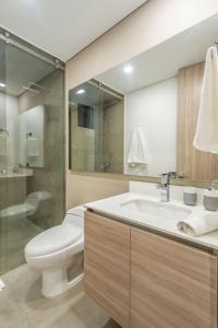La salle de bains est pourvue de toilettes, d'un lavabo et d'une douche. dans l'établissement APARTAMENTOS FACILE, à Bogotá