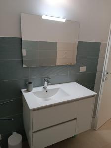 a bathroom with a sink and a mirror at Sorgenti nel bosco Appartamento vista lago in Campo Reggiano