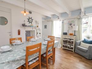 a dining room with a table and chairs at Kerbenetty Harbour Cottage in Portloe
