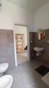 uma casa de banho com um WC, um lavatório e um espelho. em Casa Base em Bari