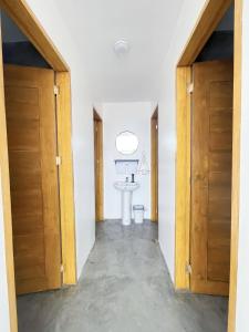 um corredor com duas portas de madeira e um lavatório em Sunset Paradise Moalboal em Moalboal