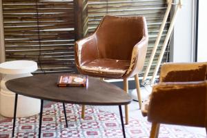 - un salon avec une chaise et une table dans l'établissement Ibis Paris Nord Villepinte Parc des Expositions, à Roissy-en-France