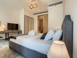 a bedroom with a bed with a desk and a television at Key View - Address JBR in Dubai