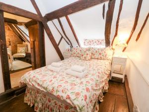 a bedroom with a bed in a room with wooden floors at Thatched Cottage in Chipping Campden