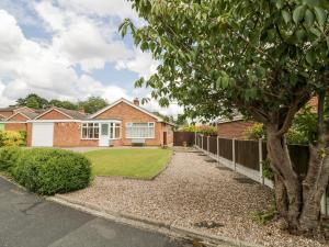 a brick house with a fence and a yard at Lynsted Lodge in Ashby de la Zouch