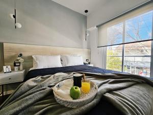 a bedroom with a bed with two glasses of orange juice at HotelN26 in Mar del Plata