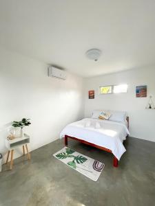 um quarto branco com uma cama e um tapete em Sunset Paradise Moalboal em Moalboal
