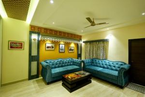 a living room with a blue couch and a table at BIGSON SERVICE APARTMENTS MADHAPUR in Hyderabad