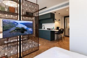 a kitchen and a living room with a tv in a room at De Sheinkin in Tel Aviv