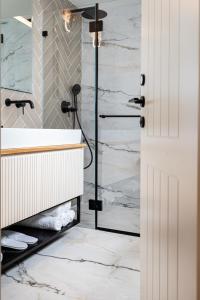 a bathroom with a shower and a white sink at De Sheinkin in Tel Aviv