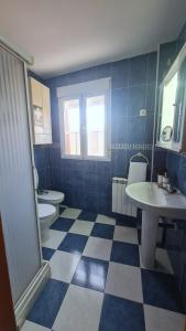 baño azul y blanco con 2 aseos y lavamanos en Las Golondrinas de Henche, 