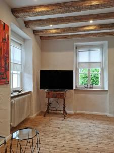 a living room with a flat screen tv and a piano at Das Kirch24 - DAS Ferienhaus in Heidenburg in Heidenburg