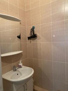un baño con lavabo y una cámara en la pared en Красивая уютная двухкомнатная квартира в Экспо, en Taldykolʼ