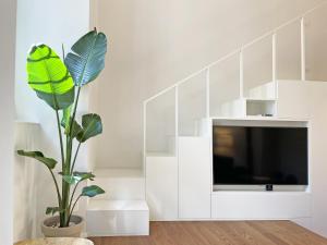 a living room with a tv and a plant at "La Portineria" Charming Apartment Old Town Como Lake in Como