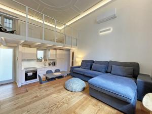 a living room with a blue couch and a kitchen at "La Portineria" Charming Apartment Old Town Como Lake in Como +19 photos
