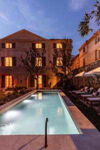 a swimming pool in front of a building at Maison Salix in Vallabrègues